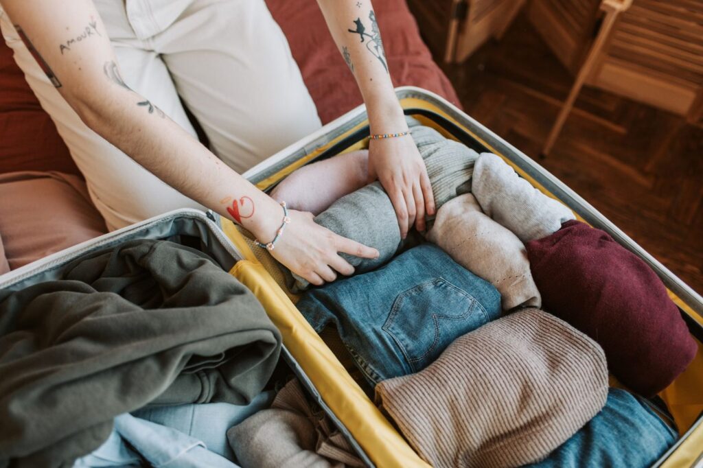 pulls et vêtements chauds pliés dans une valise, pour les soirées fraîches des Hautes Terres