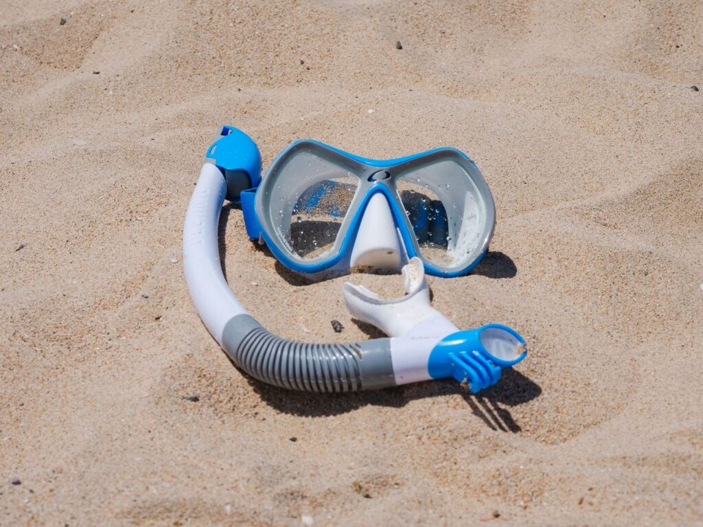 masque et tuba posés sur le sable, le complément de valise pour Sainte-Marie